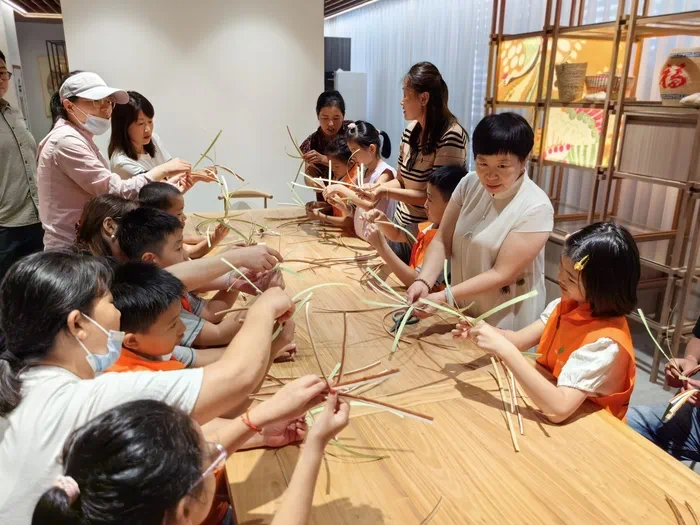 山東手造展示體驗(yàn)中心，博興草編傳承人張慧華帶孩子們體驗(yàn)草編技藝